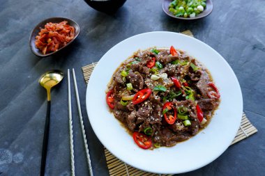 Bulgogi, soslu ve baharatlı sığır etinden yapılan bir Kore yemeğidir. siyah arkaplan