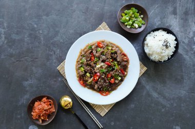 Bulgogi, soslu ve baharatlı sığır etinden yapılan bir Kore yemeğidir. siyah arkaplan