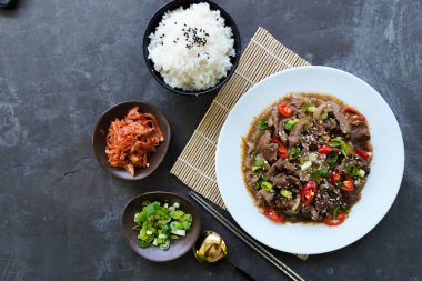 Bulgogi, soslu ve baharatlı sığır etinden yapılan bir Kore yemeğidir. siyah arkaplan