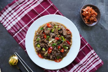 Bulgogi, soslu ve baharatlı sığır etinden yapılan bir Kore yemeğidir. siyah arkaplan