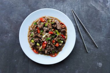 Bulgogi, soslu ve baharatlı sığır etinden yapılan bir Kore yemeğidir. siyah arkaplan