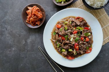 Bulgogi, soslu ve baharatlı sığır etinden yapılan bir Kore yemeğidir. siyah arkaplan