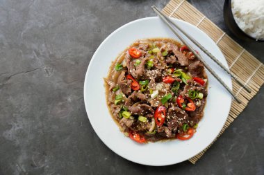 Bulgogi, soslu ve baharatlı sığır etinden yapılan bir Kore yemeğidir. siyah arkaplan