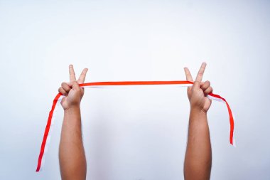 Eller, Endonezya bayrağının kırmızı ve beyaz renklerinde kurdeleleri gösteriyor.