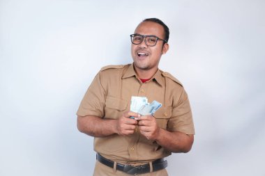 Asyalı devlet memurları ya da devlet memurları kahverengi üniformalı adamlardır. Para kazanmaktan, maaş almaktan, vergi almaktan mutluluk duyardı. Beyaz arka planda. Endonezya PNS, ASN