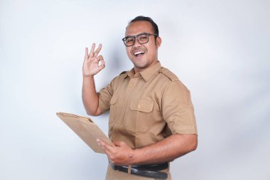 Asyalı devlet memurları ya da devlet memurları kahverengi üniformalı adamlardır. Belgeleri taşıyarak, poz vererek. Beyaz arka planda. Endonezya PNS, ASN