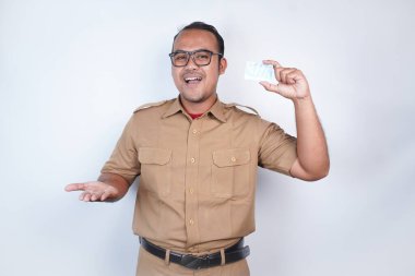 Asyalı devlet memurları ya da devlet memurları kahverengi üniformalı adamlardır. Elinde bir kimlik kartı vardı. Beyaz arka planda. Endonezya PNS, ASN