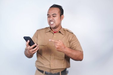 Asyalı bir devlet memuru ya da devlet memuru kahverengi üniformalı bir adama öfkeyle hitap edilir. El telefonunda kızgın. Beyaz arka planda. Endonezya PNS, ASN