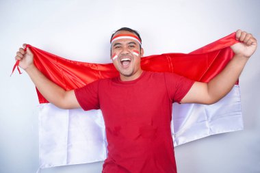 17 Ağustos 'ta Endonezya' nın bağımsızlık gününü kutlamak için bayrak kullanan Asyalı genç adam, beyaz arka planda izole edilmiş özgüvenli ve heyecanlı bir ifadeyle kameraya baktı.