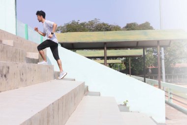 Bir adam merdivenlerden yukarı koşuyor. Kararlılık ve fiziksel çaba kavramı