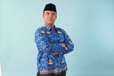 Kıs kıs gülen devlet memuru, mavi batik üniforma giyiyor. Bir PNS filmi için poz veriyor. ASN devlet memuru konsepti..