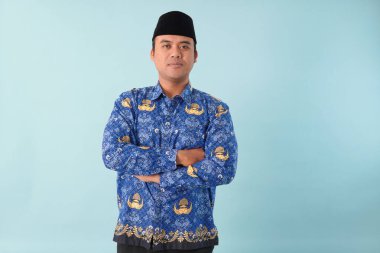 Kıs kıs gülen devlet memuru, mavi batik üniforma giyiyor. Bir PNS filmi için poz veriyor. ASN devlet memuru konsepti..