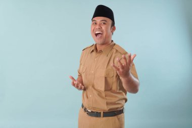 Haki üniformalı, gülümseyen bir hükümet çalışanı baş parmağını kaldırıyor. Gülümsüyor ve mutlu. Bir PNS filmi için poz veriyor, ASN devlet memuru konsepti..