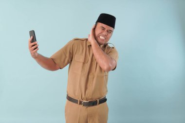 Hükümet çalışanı cep telefonuyla konuşuyor. Gülümsüyor ve PNS 'nin tadını çıkarıyor, ASN devlet memuru konsepti. Yüzüne bir cep telefonu dayadılar..