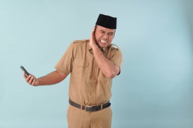 Hükümet çalışanı cep telefonuyla konuşuyor. Gülümsüyor ve PNS 'nin tadını çıkarıyor, ASN devlet memuru konsepti. Yüzüne bir cep telefonu dayadılar..