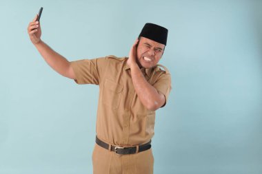 Hükümet çalışanı cep telefonuyla konuşuyor. Gülümsüyor ve PNS 'nin tadını çıkarıyor, ASN devlet memuru konsepti. Yüzüne bir cep telefonu dayadılar..