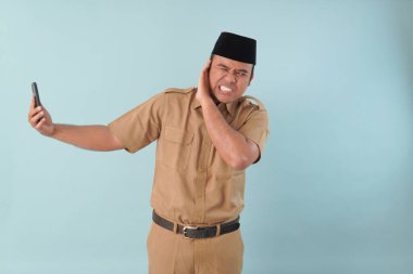 Hükümet çalışanı cep telefonuyla konuşuyor. Gülümsüyor ve PNS 'nin tadını çıkarıyor, ASN devlet memuru konsepti. Yüzüne bir cep telefonu dayadılar..