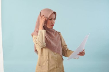 Haki üniformalı gülümseyen devlet memuru elinde PNS, ASN devlet memuru konsepti gibi poz veren bir belge tutuyor..