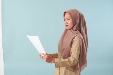 Haki üniformalı gülümseyen devlet memuru elinde PNS, ASN devlet memuru konsepti gibi poz veren bir belge tutuyor..