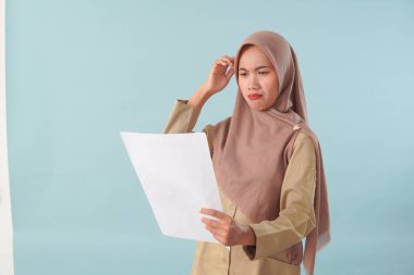 Haki üniformalı gülümseyen devlet memuru elinde PNS, ASN devlet memuru konsepti gibi poz veren bir belge tutuyor..