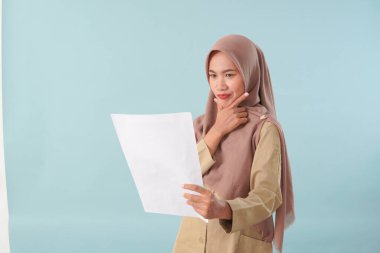 Haki üniformalı gülümseyen devlet memuru elinde PNS, ASN devlet memuru konsepti gibi poz veren bir belge tutuyor..