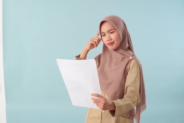 Haki üniformalı gülümseyen devlet memuru elinde PNS, ASN devlet memuru konsepti gibi poz veren bir belge tutuyor..