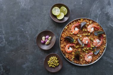 Paella, pirinç, deniz ürünleri, karides, istiridye, limon ve safran soslu bezelye karışımı bir İspanyol yemeğidir..