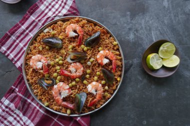 Paella, pirinç, deniz ürünleri, karides, istiridye, limon ve safran soslu bezelye karışımı bir İspanyol yemeğidir..