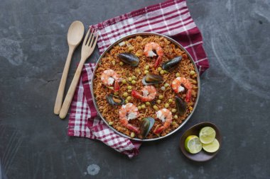 Paella, pirinç, deniz ürünleri, karides, istiridye, limon ve safran soslu bezelye karışımı bir İspanyol yemeğidir..