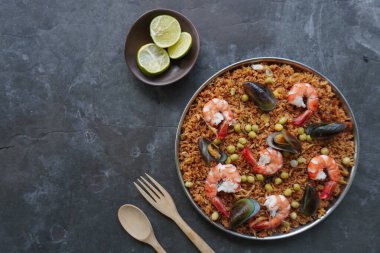 Paella, pirinç, deniz ürünleri, karides, istiridye, limon ve safran soslu bezelye karışımı bir İspanyol yemeğidir..