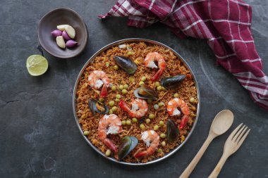 Paella, pirinç, deniz ürünleri, karides, istiridye, limon ve safran soslu bezelye karışımı bir İspanyol yemeğidir..