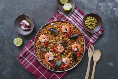 Paella, pirinç, deniz ürünleri, karides, istiridye, limon ve safran soslu bezelye karışımı bir İspanyol yemeğidir..