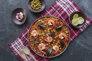 Paella, pirinç, deniz ürünleri, karides, istiridye, limon ve safran soslu bezelye karışımı bir İspanyol yemeğidir..
