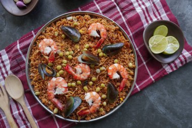 Paella, pirinç, deniz ürünleri, karides, istiridye, limon ve safran soslu bezelye karışımı bir İspanyol yemeğidir..