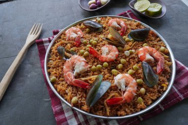 Paella, pirinç, deniz ürünleri, karides, istiridye, limon ve safran soslu bezelye karışımı bir İspanyol yemeğidir..