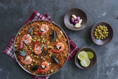 Paella, pirinç, deniz ürünleri, karides, istiridye, limon ve safran soslu bezelye karışımı bir İspanyol yemeğidir..