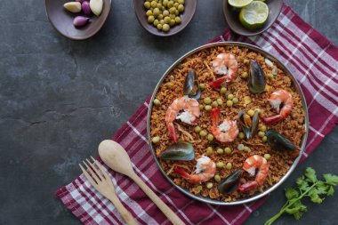 Paella, pirinç, deniz ürünleri, karides, istiridye, limon ve safran soslu bezelye karışımı bir İspanyol yemeğidir..