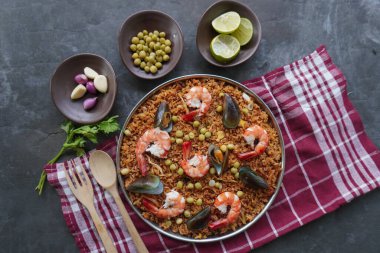 Paella, pirinç, deniz ürünleri, karides, istiridye, limon ve safran soslu bezelye karışımı bir İspanyol yemeğidir..