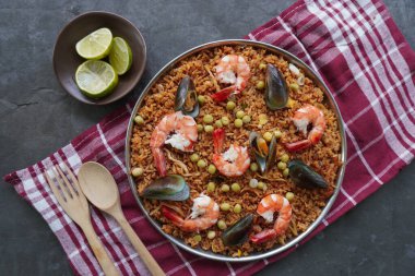 Paella, pirinç, deniz ürünleri, karides, istiridye, limon ve safran soslu bezelye karışımı bir İspanyol yemeğidir..