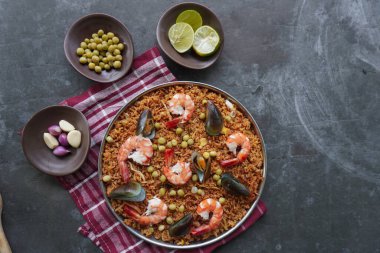 Paella, pirinç, deniz ürünleri, karides, istiridye, limon ve safran soslu bezelye karışımı bir İspanyol yemeğidir..