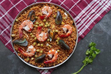 Paella, pirinç, deniz ürünleri, karides, istiridye, limon ve safran soslu bezelye karışımı bir İspanyol yemeğidir..
