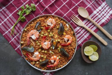 Paella, pirinç, deniz ürünleri, karides, istiridye, limon ve safran soslu bezelye karışımı bir İspanyol yemeğidir..