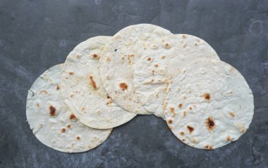 Un Tortilla Paketleri Ev yapımı buğday tortillası, Pita ekmeği, tortilla, masada pişirmek için malzemeli pide. Üst Manzara. Ev yapımı yemek kavramı..