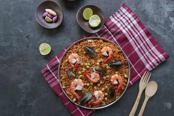 Paella, pirinç, deniz ürünleri, karides, istiridye, limon ve safran soslu bezelye karışımı bir İspanyol yemeğidir..