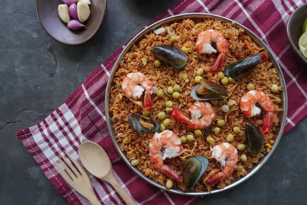 Paella, pirinç, deniz ürünleri, karides, istiridye, limon ve safran soslu bezelye karışımı bir İspanyol yemeğidir..