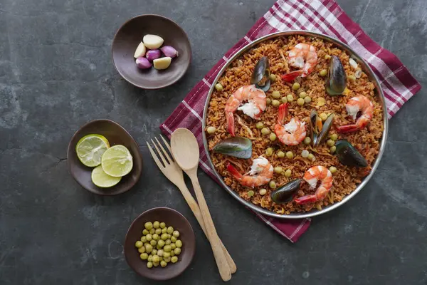 Paella, pirinç, deniz ürünleri, karides, istiridye, limon ve safran soslu bezelye karışımı bir İspanyol yemeğidir..