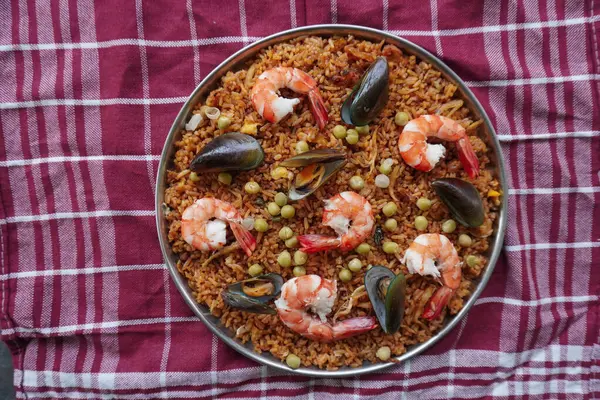 Paella, pirinç, deniz ürünleri, karides, istiridye, limon ve safran soslu bezelye karışımı bir İspanyol yemeğidir..