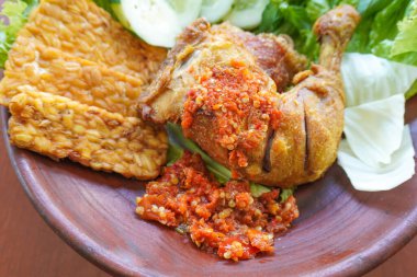 Ayam penyet, Endonezya 'da kızarmış tavuk çeşididir ve tavuk, salatalık dilimi, kızarmış tempo, marul, sambal ve biber ile servis edilir.