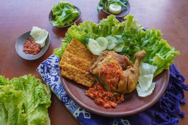 Ayam penyet, Endonezya 'da kızarmış tavuk çeşididir ve tavuk, salatalık dilimi, kızarmış tempo, marul, sambal ve biber ile servis edilir.