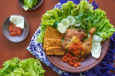 Ayam penyet, Endonezya 'da kızarmış tavuk çeşididir ve tavuk, salatalık dilimi, kızarmış tempo, marul, sambal ve biber ile servis edilir.